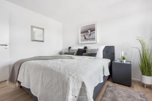 a white bedroom with a bed and a plant at Marina Sunrise in Olpenitz +17 photos