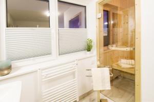 オルペニッツにあるHeimathafenの白いキャビネットと窓、椅子付きのバスルーム