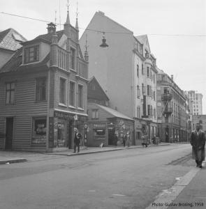 a black and white photo of a street with buildings at Live in historic building - View to Bryggen in Bergen