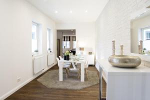 een witte keuken met een tafel en een eetkamer bij Penthouse am Glockenturm in Flensburg
