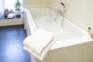 a bathroom with a shower and a white bathtub at Penthouse am Glockenturm in Flensburg