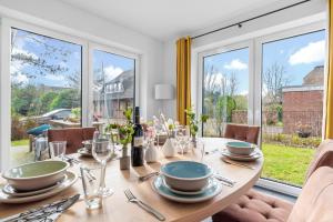 a dining room with a table and a large window at Böe in Sankt Peter-Ording
