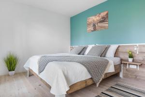 a bedroom with a bed and a blue wall at Böe in Sankt Peter-Ording