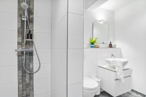 a white bathroom with a shower and a toilet at Böe in Sankt Peter-Ording +8 photos