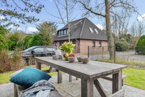 a wooden picnic table with bowls of fruit on it at Böe in Sankt Peter-Ording