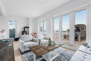 un soggiorno con mobili bianchi e ampie finestre di Ausguck 34 a Olpenitz