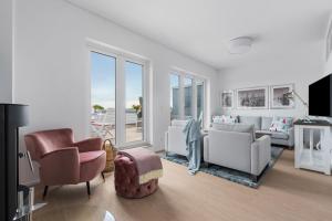 un soggiorno con mobili bianchi e ampie finestre di Ausguck 34 a Olpenitz