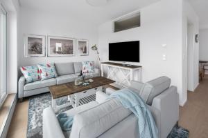 un soggiorno con due divani e una TV di Ausguck 34 a Olpenitz