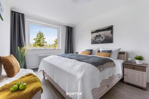 ein weißes Schlafzimmer mit einem Bett und einem Fenster in der Unterkunft Wikingeck Schleiblick in Schleswig