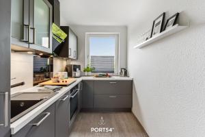 eine Küche mit grauen Schränken und einem Fenster in der Unterkunft Wikingeck Schleiblick in Schleswig