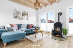 a living room with a blue couch and a fireplace at Nordic Lodge in Büsum