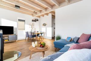 a living room with a blue couch and a table at Ferienhaus Nordseeresort 32 Nordic Lodge Büsum in Büsum