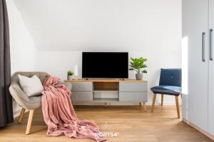 sala de estar con TV y manta en Nordic Lodge, en Büsum