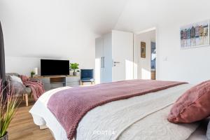 a bedroom with a large bed and a tv at Nordic Lodge in Büsum