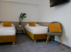 Pokój z 2 łóżkami i krzesłem w obiekcie Centrum Szkoleniowo-Konferencyjne Społem w Warszawie