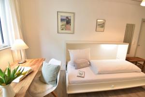 ein kleines Schlafzimmer mit einem Bett und einem Schreibtisch in der Unterkunft Stadtloft in Flensburg