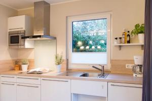 eine Küche mit einem Waschbecken und einem Fenster in der Unterkunft Möwennest Solitüde in Flensburg
