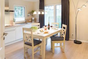 a kitchen with a table and chairs with drinks and food on it at Möwennest Solitüde in Flensburg