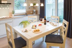 a kitchen with a table with food and glasses of wine at Möwennest Solitüde in Flensburg +10 photos
