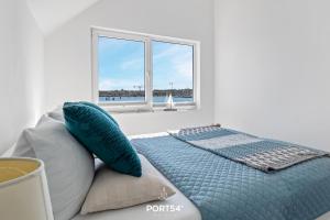 um quarto com uma cama com almofadas e uma janela em Sea Bay em Olpenitz