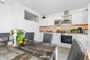 a kitchen with white cabinets and a table with fruit on it at Sonnenlicht in Olpenitz