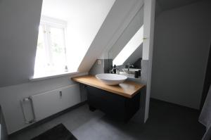 een badkamer met een wastafel en een raam bij Linde in Flensburg