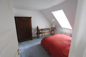 een slaapkamer met een rood bed en een tafel bij Linde in Flensburg