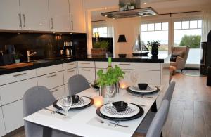 a kitchen with a white table with chairs and a dining room at Strandhaus Fördeblick in Langballig