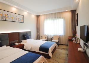 Chongqing Jianfeng Hotel في Fuling: غرفة فندقية بسريرين وتلفزيون بشاشة مسطحة