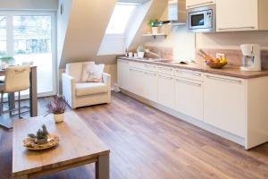 a kitchen with white cabinets and a table at Strandquartier Solitüde in Flensburg