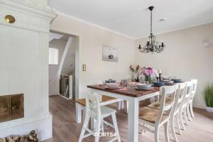 a white dining room with a table and chairs at Reethüs Schleiblick in Selk