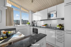 a kitchen with white cabinets and a large window at Ferienhaus Ostseelchen Marina Wendtorf in Wendtorf