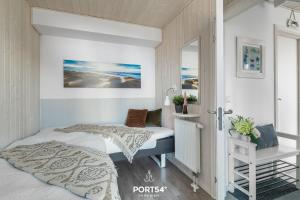 a bedroom with two beds and a mirror at Ferienhaus Ostseelchen Marina Wendtorf in Wendtorf
