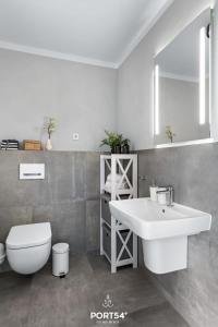 La salle de bains est pourvue d'un lavabo blanc et de toilettes. dans l'établissement Hannes, à Büsum