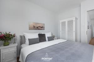 a white bedroom with a large bed in it at Ocean Lounge in Olpenitz