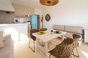Arenas del Mar Formentera في Es Arenals: مطبخ وغرفة معيشة مع طاولة وكراسي