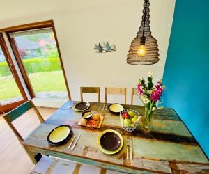 a table with plates and a vase of flowers on it at Schlunz in Kappeln