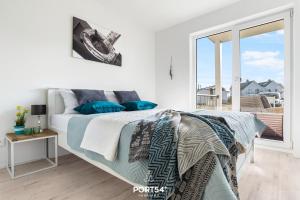 a bedroom with a bed with blue pillows and a balcony at Dünenpalais in Olpenitz