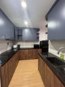 a kitchen with wooden cabinets and black counter tops at ChouChou Apartment in Danang