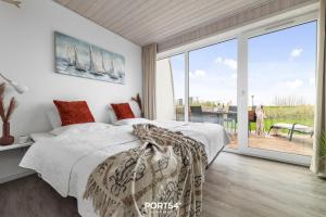 a bedroom with a bed and a large window at Ferienhaus Marina Lounge Wendtorf in Wendtorf