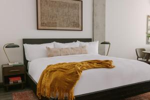 - une chambre avec un lit blanc et une couverture dans l'établissement Sonder Lambert, à Montréal