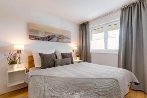 a bedroom with a large bed and a window at Marina Sunset West in Olpenitz