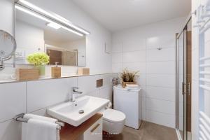 a white bathroom with a sink and a toilet at Marina Sunset West in Olpenitz
