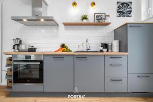 uma cozinha com electrodomésticos de aço inoxidável e paredes brancas em Little Lobster em Flensburg