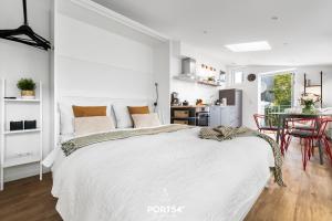 Un dormitorio blanco con una cama grande y una mesa en Little Lobster, en Flensburg