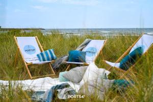 twee stoelen in het zand aan het strand bij Seewind in Olpenitz