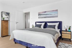 Un dormitorio con una cama azul y una pared blanca en Lila Wolke, en Olpenitz