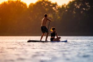 um homem e uma mulher numa prancha de paddle na água em Seewind em Olpenitz
