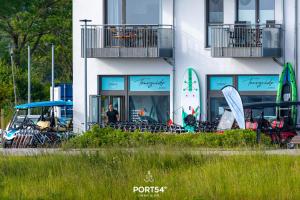 um homem parado em frente a um edifício com pranchas de surf em Seewind em Olpenitz