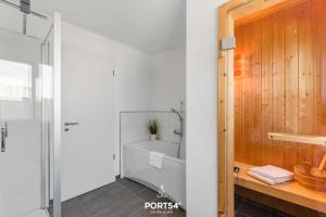a bathroom with a bath tub and a shower at Maison de la mer in Olpenitz